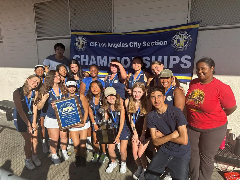 The girls tennis team poses after winning the championship game.
